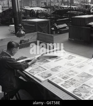 1950er-Jahren, historische, Produktionsleiter sitzen an einem großen Tisch in der Ecke der Fabrik durchläuft den Seiten einer Zeitschrift, die gerade gedruckt worden ist, Fehler und Qualität suchen, Stockfoto