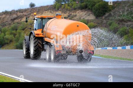 Ein Traktor spritzt Wasser, um die Strecke zu benetzen, um die morgendliche Sitzung während des Formel-1-Tests 2014 auf dem Circuito de Jerez, Jerez, Spanien, zu einem künstlichen Nass-Test zu machen. Stockfoto