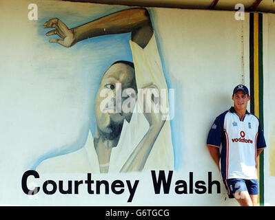 England Fast Bowler Simon Jones, entspannt sich gegen ein Wandplakat von legenendary Jamaican und West-indischen Fast Bowler Courtney Walsh in Kingston, Jamaika. Stockfoto