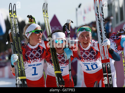 Olympische Winterspiele In Sotschi - Tag 15. Die norwegische Marit Bjoergen (Mitte) feiert mit Therese Johaug (links) und Kristin Stoermer Steira den Gewinn des 30 km langen Ladies Cross County Stockfoto
