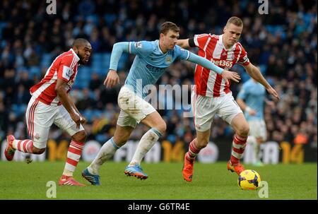 Edin Dzeko von Manchester City kämpft mit Ryan Shawcross von Stoke City (rechts) und Wilson Palacios (links) während des Spiels der Barclays Premier League im Etihad Stadium in Manchester um den Ball. Stockfoto