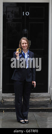 Die britische Lizzy Yarnold, Goldmedaillengewinnerin des Women's Skeleton, von den Olympischen Spielen 2014 in Sotschi, hält ihre Medaille vor der Downing Street 10 in London, nachdem sie zu einem Treffen mit Premierminister David Cameron gekommen war. Stockfoto