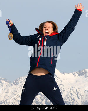 Die große Britin Lizzy Yarnold mit ihrer Goldmedaille hoch über den Bergen bei Rosa Khutor, nachdem sie das Frauenskelett bei den Olympischen Spielen in Sotschi 2014 in Russland gewonnen hatte. Stockfoto