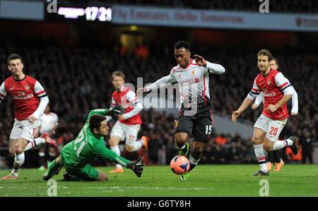 Liverpools Daniel Sturridge (zweiter rechts) versucht, den Ball um Arsenal-Torwart Lukasz Fabianski zu holen Stockfoto