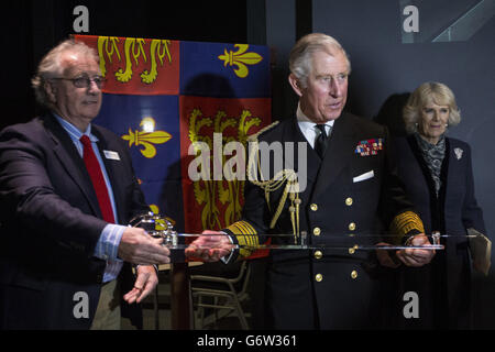 Charles Barker (links), Direktor der archäologischen Dienste von Mary Rose, überreicht dem Prinzen von Wales ein zeremonielles Schwert, das von der Herzogin von Cornwall bei einem Besuch im neuen 35 Millionen Mary Rose Museum in Portsmouth Historic Dockyard, Hampshire, beobachtet wird, in dem die Überreste des Tudor-Kriegsschiffs Mary Rose untergebracht sind. Stockfoto