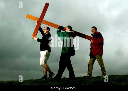 Pilger tragen ein hölzernes Kreuz durch die Felder im Castle Rising, das fünf Meilen nördlich von Kings Lynn in Norfolk liegt, dieser Gründungauf ihrer Pilgerfahrt zum christlichen Schrein in Walsingham, Norfolk, wo sich traditionell Hunderte versammeln, um über Ostern anzubeten. Stockfoto