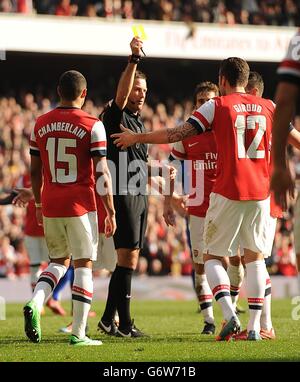 Schiedsrichter Mark Clattenburg zeigt Arsenals Olivier Giroud eine gelbe Karte, weil er während der ersten Strafe von Mikel Arteta eingegriffen hat Stockfoto