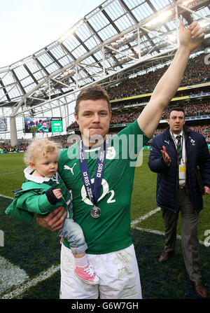 Der irische Brian O'Driscoll trägt seine Tochter Sadie nach seinem letzten Heimspiel beim RBS Six Nations-Spiel im Aviva Stadium, Dublin, Irland, auf dem Spielfeld. Stockfoto