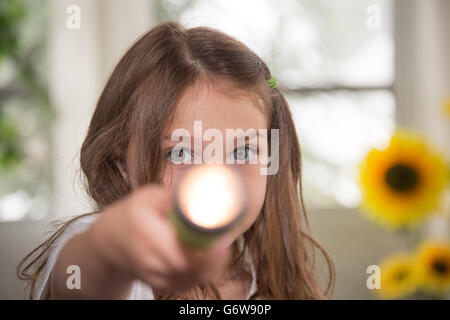 Kleinkind spielt mit einer Taschenlampe. Stockfoto