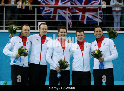 Großbritannien (von links nach rechts) Tom Brewster, Michael Goodfellow, Scott Andrews, Greg Drummond und David Murdoch während der Blumenzeremonie, nachdem sie bei den Olympischen Spielen in Sotschi 2014 im Eiswürfel-Curling-Center Silber beim Goldmedaillenspiel der Männer gewonnen hatten. Stockfoto