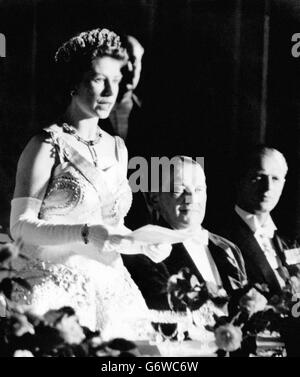 Königin Elizabeth II., die auf Französisch spricht, reagiert auf den Toast des französischen Präsidenten Rene Coty (Mitte) bei einem Abendessen im Elysée-Palast, Paris, am ersten Tag des viertägigen Staatsbesuchs. Der Herzog von Edinburgh hört extrem rechts zu. Stockfoto