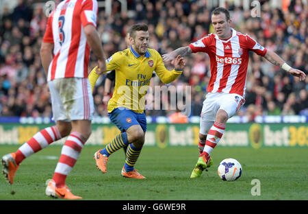 Jack Wilshere von Arsenal kämpft während des Spiels der Barclays Premier League im Britannia Stadium, Stoke-on-Trent, mit Glenn Whelan von Stoke City um den Ball. Stockfoto