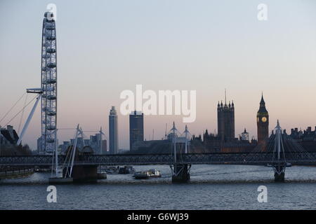 Abendansicht in der Dämmerung des Palace of Westminster (rechts) und des London Eye (links) hinter der Charing Cross Bridge von der Waterloo Bridge aus gesehen. Stockfoto
