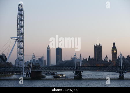 Abendansicht in der Dämmerung des Palace of Westminster (rechts) und des London Eye (links) hinter der Charing Cross Bridge von der Waterloo Bridge aus gesehen. Stockfoto