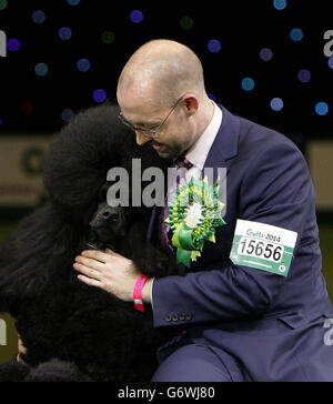 Der zweijährige Standard-Pudel Ricky mit seinem Handler Jason Lynn gewann den prestigeträchtigsten Hundeschau-Preis der Welt, nachdem er die diesjährige Best-in-Show bei Crufts im NEC in Birmingham bewertet wurde. Stockfoto