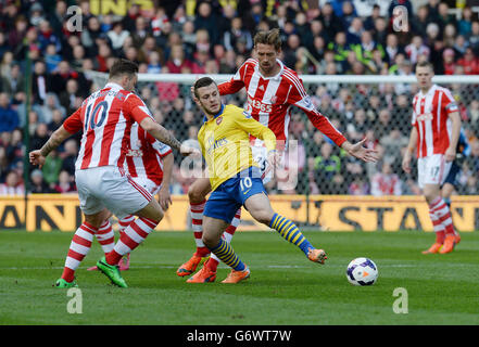 Arsenals Jack Wilshere kämpft mit Peter Crouch und Marko Arnautovic (links) von Stoke City während des Barclays Premier League-Spiels im Britannia Stadium, Stoke-on-Trent. Stockfoto