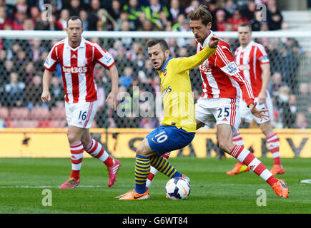 Jack Wilshere von Arsenal kämpft während des Spiels der Barclays Premier League im Britannia Stadium in Stoke-on-Trent mit Peter Crouch von Stoke City um den Ball. Stockfoto