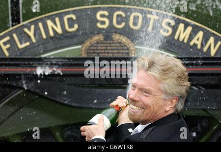Sir Richard Branson sprüht Champagner auf der britischen Dampfeisenbahn The Flying Scotsman im Westen Londons. Die Befürchtung, dass der 80 Jahre alte Motor ins Ausland verkauft werden würde, wurde nach einer Spende von Sir Richard aus dem Jahr 365,000 sowie öffentlichen Spenden von 425,000 und 1.8 Millionen aus dem National Heritage Memorial Fund, der die Zukunft der Lok im Vereinigten Königreich gesichert hat, aufgehoben. Stockfoto