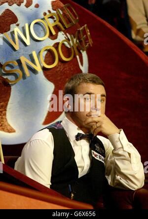 Der schottische Stephen Hendry beobachtet von seinem Sitz aus während seines Halbfinalmatches gegen Ronnie O'Sullivan bei den 2004 Embassy World Snooker Championships im Crucible Theatre, Sheffield. Stockfoto