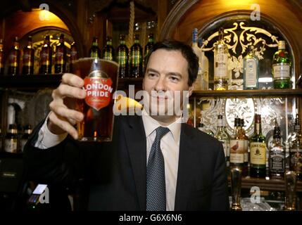 Der Schatzkanzler George Osborne hält ein Pint Bier während eines Besuchs, um den Red Lion Pub nach einer großen Renovierung in Whitehall, im Zentrum von London, offiziell wieder zu eröffnen. Stockfoto