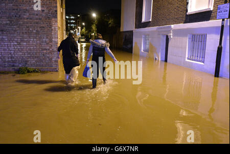 Kennington-Überschwemmung. Die Menschen laufen durch das Hochwasser einer gesprengte Hauptleitung in der Clapham Road in Kennington im Süden Londons. Stockfoto