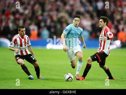 Samir Nasri (Mitte) von Manchester City spielt den Ball zwischen Emanuele Giaccherini (links) von Sunderland und Marcos Alonso (rechts) Stockfoto