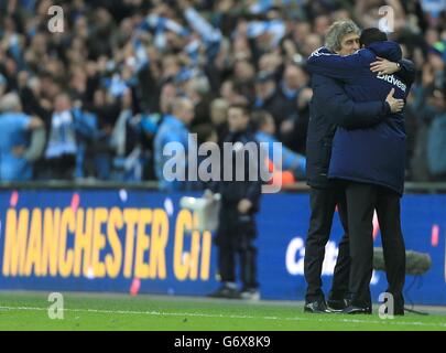 Fußball - Capital One Cup - Finale - Manchester City gegen Sunderland - Wembley Stadium. Manchester City Manager Manuel Pellegrini (links) umarmt den Sunderland Manager Gustavo Poyet nach dem letzten Pfiff Stockfoto