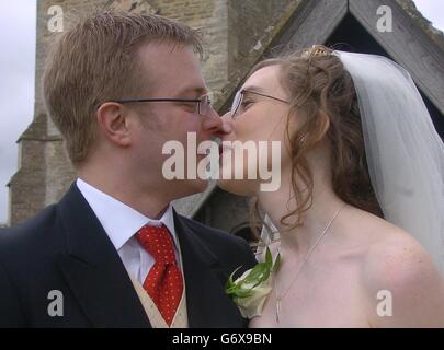 Das glückliche Paar Matthew und Rebekah Jones teilen sich einen Kuss, nachdem sie in St. Mary Magdalene Chuch in South Marston, in der Nähe von Swindon in Wiltshire, geheiratet haben. Matthew ist nun die 11. Generation in seiner Familie, die in der gleichen Kirche als Teil einer Tradition, die sich bis 1690. Matthew, 28, musste eine besondere Erlaubnis einholen, um diese Tradition fortzusetzen, nachdem er jetzt in Rugby lebt, um seine Braut, Rebekah, die aus Devon stammt, zu heiraten. Stockfoto