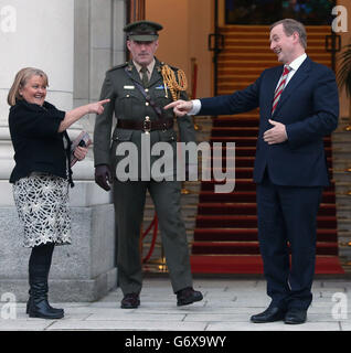 Taoiseach Enda Kenny teilt einen Witz mit dem amerikanischen Amtsinhalt (links, Name nicht bekannt), da sein Adjutant Kommandant Kieran Carey (Mitte) auf die Ankunft des ehemaligen US-Präsidenten Bill Clinton in Regierungsgebäuden in Dublin wartet. Stockfoto