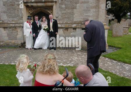 Ein Fotograf fotografiert Hochzeit des glücklichen Paares Matthew und Rebekka Jones Nachdem sie am St. Mary Magdalene Chuch in South Marston, in der Nähe von Swindon in Wiltshire, Samstag, 3. April 2004 verheiratet gewesen war. Matthew ist inzwischen der 11. Generation in seiner Familie, in der gleichen Kirche als Teil einer Tradition, die zurück reicht bis 1690 zu heiraten. Matthäus 28, musste suchen besondere Erlaubnis, diese Tradition fortzusetzen, da er in Rugby, lebt um seine Braut, Rebekka, zu heiraten, der aus Devon stammt. PA-Foto: Johnny Green. Stockfoto