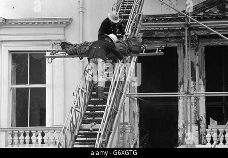 Feuerwehrleute, die eine von zwei Leichen entfernen, die bisher in den verbrannten Resten der iranischen Botschaft in London gefunden wurden. Die Leiche, in einen dunkelgrünen Leichensack gewickelt, wurde von einem Fenster im zweiten Stock des Gebäudes im Princes Gate, Kensington, abgesenkt und von einem Leichenwagen mitgenommen. Stockfoto