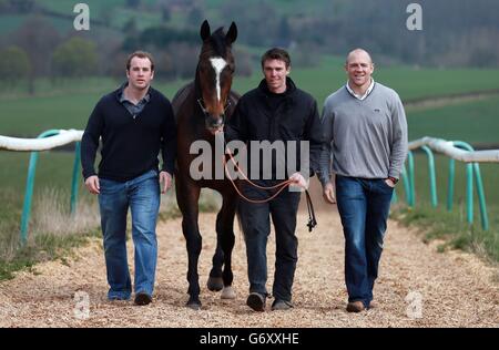 Trainer Michael Scudamore (Mitte) und Teilhaber Mike Tindall (rechts) und James Simpson-Daniel (links) mit Monbeg Dude während des Stallbesuchs im Eccleswall Court, Ross-on-Wye. Stockfoto