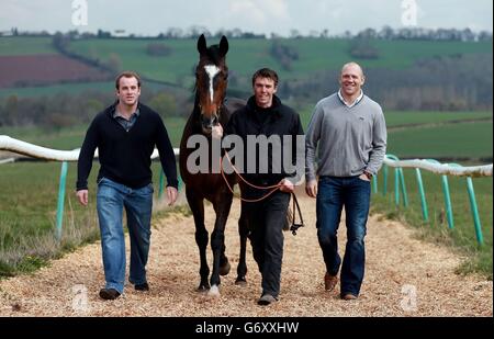 Trainer Michael Scudamore (Mitte) mit den Teileinhabern Mike Tindall (rechts) und James Simpson-Daniel (links) mit Monbeg Dude während des Stallbesuchs im Eccleswall Court, Ross-on-Wye. Stockfoto