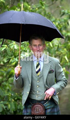 Der Prinz von Wales, der Herzog von Rothsey, schützt vor den April-Regenschauern bei einem Besuch im Fyvie Castle in Aberdeenshire, um das North East of Scotland Skills Training Center zu besichtigen. Stockfoto