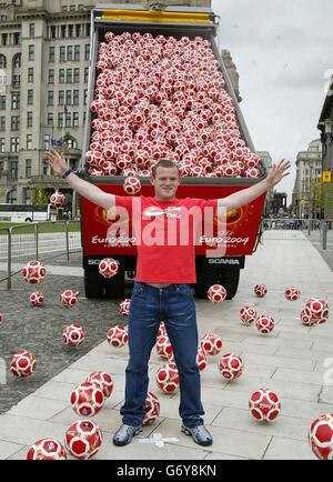 Everton-Star Wayne Rooney mit Tausenden von Coca-Cola-Fußbällen, die auf den Straßen von Liverpool veröffentlicht wurden. Die Softdrinks-Firma bringt die Nation in diesem Sommer in den Treten, indem sie eine Million Fußbälle auf speziellen Dosen, Flaschen und Multipacks von "Coca-Cola" verschenkt und eine "Get Kicking"-Tour startet, um alle im ganzen Land zu ermutigen, Spaß beim Kicking zu haben. Stockfoto