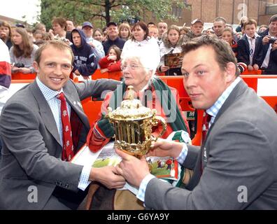 Mitglieder von Englands WM-Siegesmannschaft, Scrum Half Matt Dawson und Steve Thompson in der ersten Reihe (rechts) zeigen die Webb Ellis Trophy der 95-jährigen Ella Clarke von Hinckley, einer lebenslangen Unterstützerin von Leicester Tigers, während eines Rugby-Besuches in Warwickshire. Das Team erhielt die Freiheit der Stadt, wo das Rugby-Spiel entstand. Stockfoto