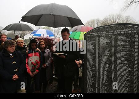 Lorraine Jackson (links) aus Killenard, Laois, die kurz nach ihrer Geburt neun Monate im Haus verbracht hat, hört Kanon Mark Gardiner bei einer Zeremonie lesen, um 222 Kindern aus dem Bethany Mutter- und Kinderheim auf dem Mount Jerome Cemetery, Harold's Cross, Dublin, ein Denkmal zu enthüllen. Stockfoto