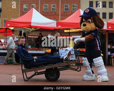 David Willey von Northamptonshire sitzt auf einem Marktkarren auf dem Market Square, im Stadtzentrum von Northampton, mit dem Clubmaskottchen Steeler The Dog???? Als sie auf diese Saison warten, ist die Medienfotozelle Northampton. Stockfoto