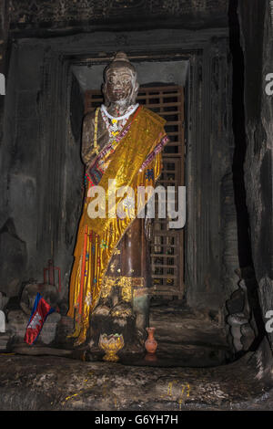 Buddha-Statue drapiert mit einem dekorierten Goldstoff unter der zentralen Kuppel (Einkehr) von Angkor Wat, Kambodscha Stockfoto