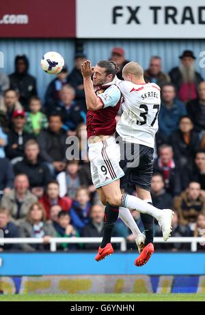 Andy Carroll von West Ham United (links) und Martin Skrtel von Liverpool (Rechts) Kampf um den Ball in der Luft Stockfoto