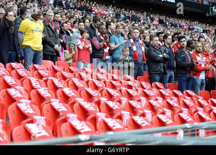 Arsenal-Fans werden während einer Minutenerinnerungan die 96 Sitze, die als Tribut an die 96 Liverpool-Fans, die bei der Katastrophe von Hillsborough ihr Leben verloren haben, leer gelassen werden, vor dem Halbfinale des FA Cup im Wembley Stadium in London gesehen. Stockfoto