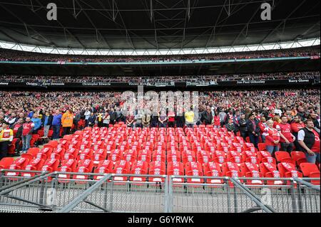 Arsenal-Fans werden während einer Minutenerinnerungan die 96 Sitze, die als Tribut an die 96 Liverpool-Fans, die bei der Katastrophe von Hillsborough ihr Leben verloren haben, leer gelassen werden, vor dem Halbfinale des FA Cup im Wembley Stadium in London gesehen. Stockfoto