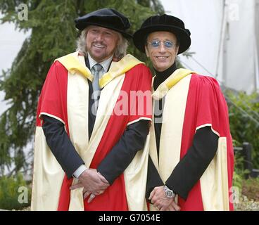 Die Bee Gees, Barry (links) und Robin Gibb posieren für Fotografen, nachdem sie den Ehrendoktortitel (Doktor der Musik) an der Universität von Manchester erhalten haben. Die Brüder nahmen auch einen posthumen Ehrendoktortitel im Namen ihres verstorbenen Bruders Maurice an, der im Januar 2003 starb. Stockfoto