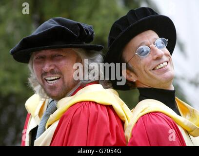 Die Bee Gees, Barry (links) und Robin Gibb posieren für Fotografen, nachdem sie den Ehrendoktortitel (Doktor der Musik) an der Universität von Manchester erhalten haben. Die Brüder nahmen auch einen posthumen Ehrendoktortitel im Namen ihres verstorbenen Bruders Maurice an, der im Januar 2003 starb. Stockfoto