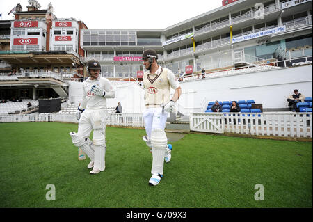 Cricket - LV= County Championship - Division Two - Day One - Surrey / Glamorgan - Kia Oval. Surrey eröffnet die Batsmen Rory Burns (links) und Kapitän Graeme Smith gehen am Kia Oval raus Stockfoto