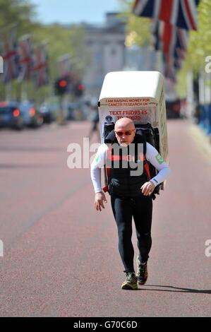 Charity-Läufer Tony Phoenix-Morrison, bekannt als Tony the Fridge on the Mall, als er die London Marathons hinter sich führt, während er einen Kühlschrank trägt. Stockfoto