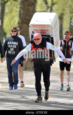 Charity-Läufer Tony Phoenix-Morrison, bekannt als Tony the Fridge on the Mall, als er die London Marathons hinter sich führt, während er einen Kühlschrank trägt. Stockfoto