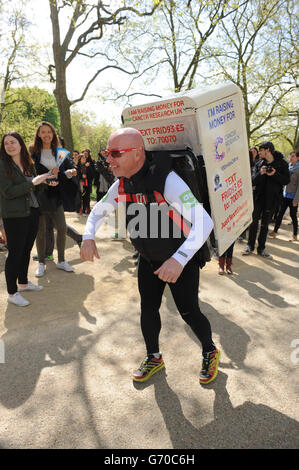 Charity-Läufer Tony Phoenix-Morrison, bekannt als Tony the Fridge on the Mall, als er die London Marathons hinter sich führt, während er einen Kühlschrank trägt. Stockfoto