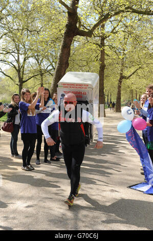 Charity-Läufer Tony Phoenix-Morrison, bekannt als Tony the Fridge on the Mall, als er die London Marathons hinter sich führt, während er einen Kühlschrank trägt. Stockfoto