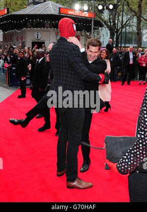 Andrew Garfield, der mit einem als Spiderman verkleideten Mann bei der Weltpremiere des Films The Amazing Spiderman 2 auf dem Odeon Leicester Square im Zentrum von London herumlunzt. Stockfoto